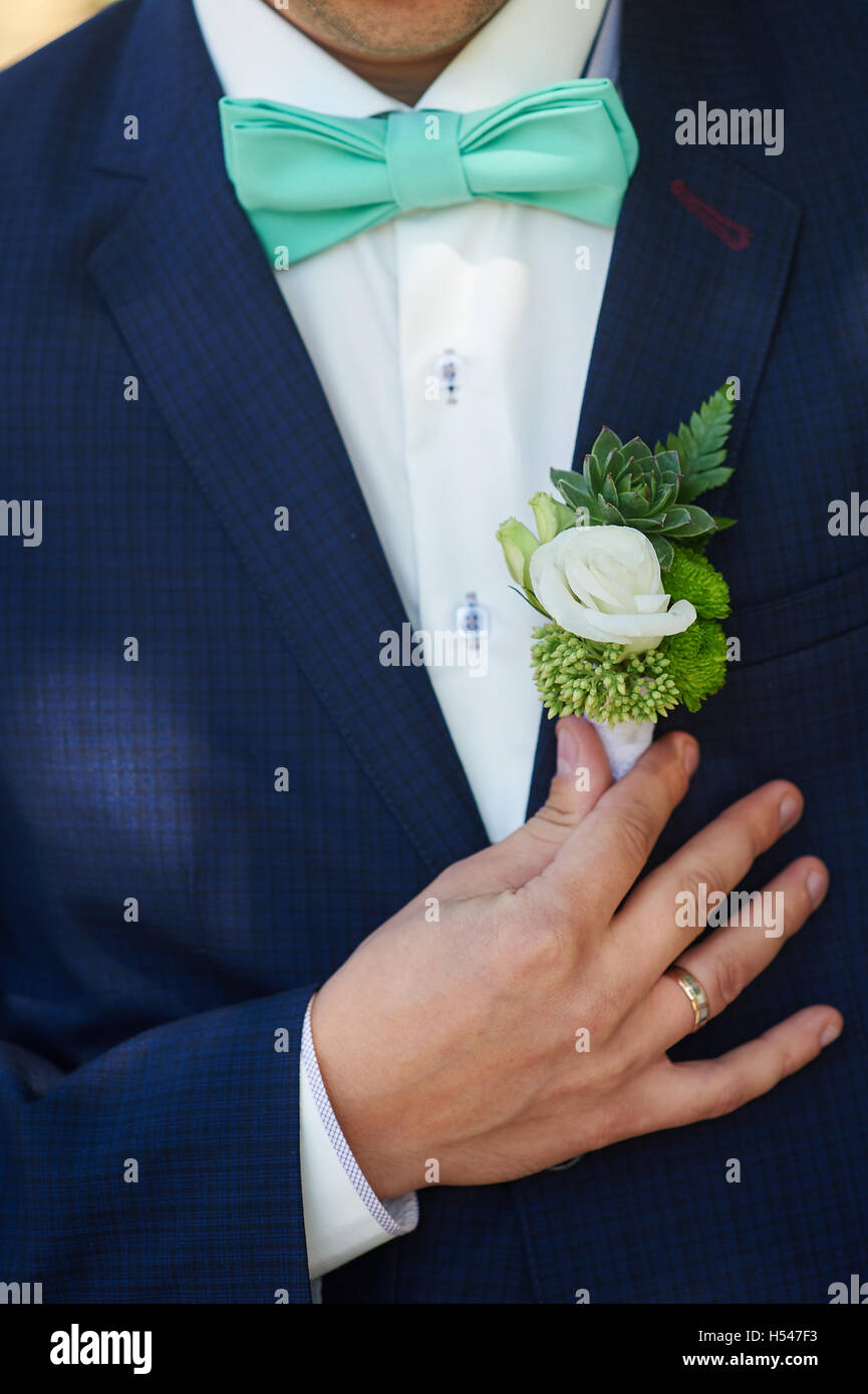 Boutonnière pour le marié ajuste sa main dans une poche de veste Banque D'Images