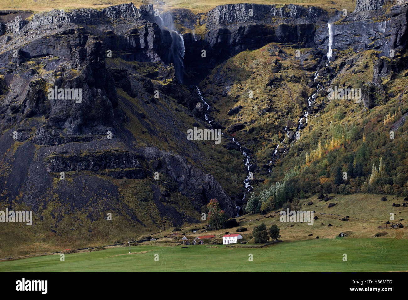 Maison de campagne, en montagne sous une cascade, est de l'Islande, de l'Atlantique Nord, Europe Banque D'Images