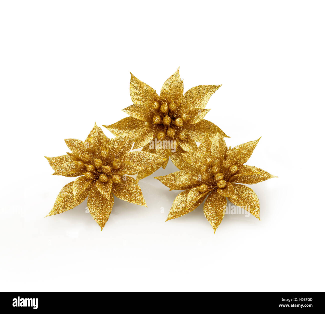 Trois fleurs de fantaisie de Noël avec des paillettes contre fond blanc et l'ombre douce. Chemin de détourage sur des fleurs Banque D'Images