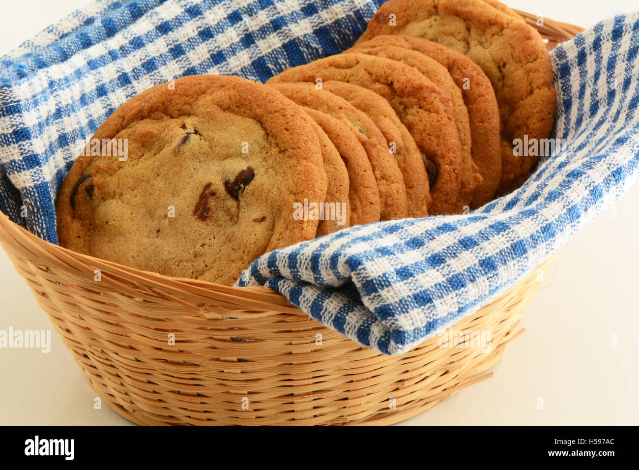 Fresh baked chocolate chip cookies dans panier sur bleu et blanc serviette en format horizontal. Macro avec shallow DOF. Banque D'Images