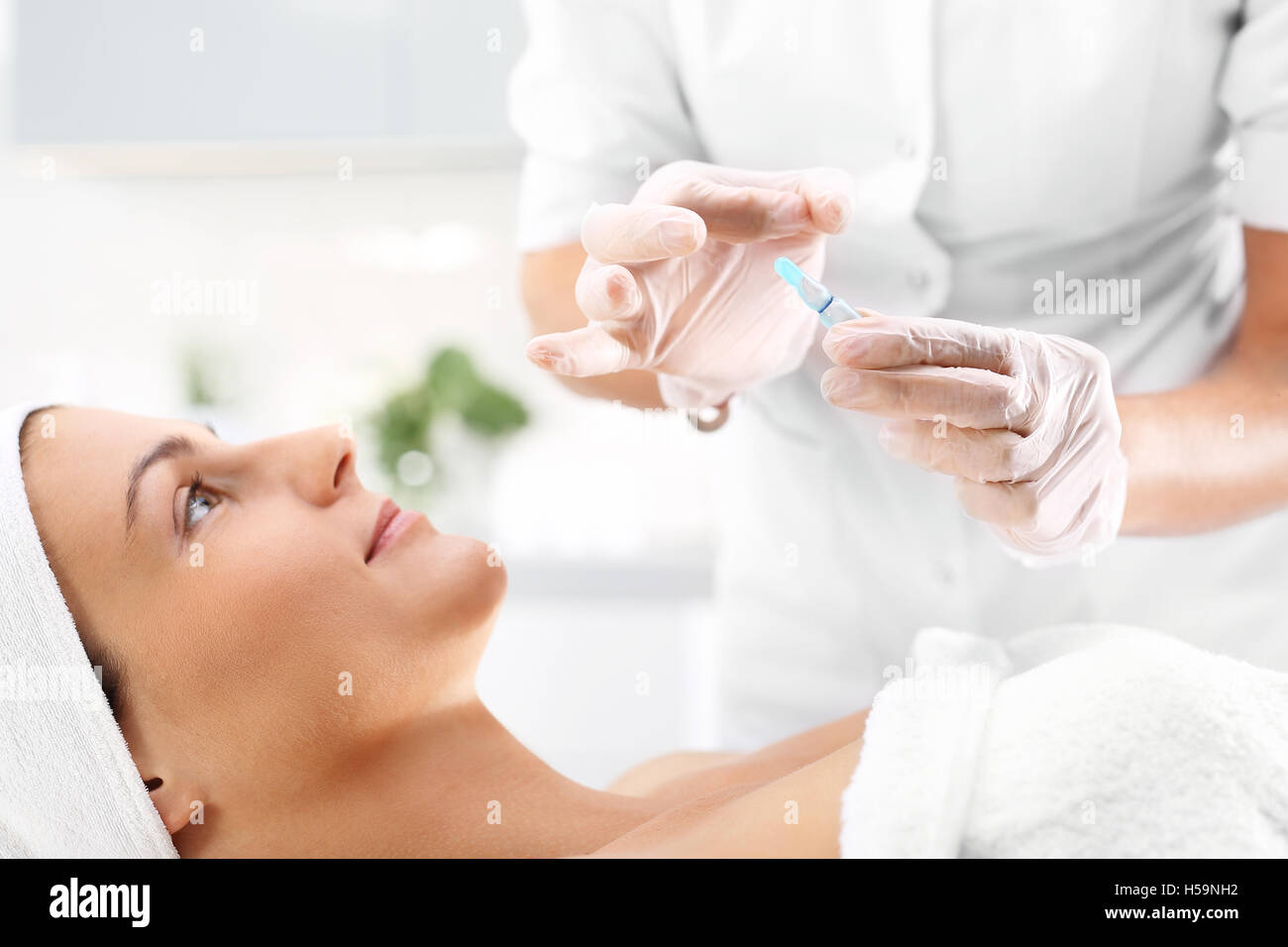 Ampoule cosmétique, une femme dans le salon de beauté, de la vitamine C dans les cosmétiques ampoule. Banque D'Images