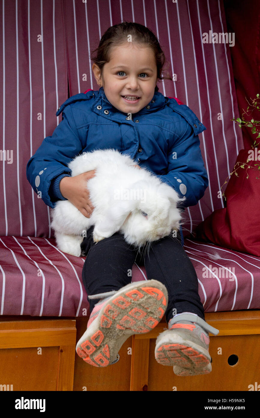 Jeune fille lapin caressant au Children's farm Kirchdorf, Hambourg, Allemagne Banque D'Images