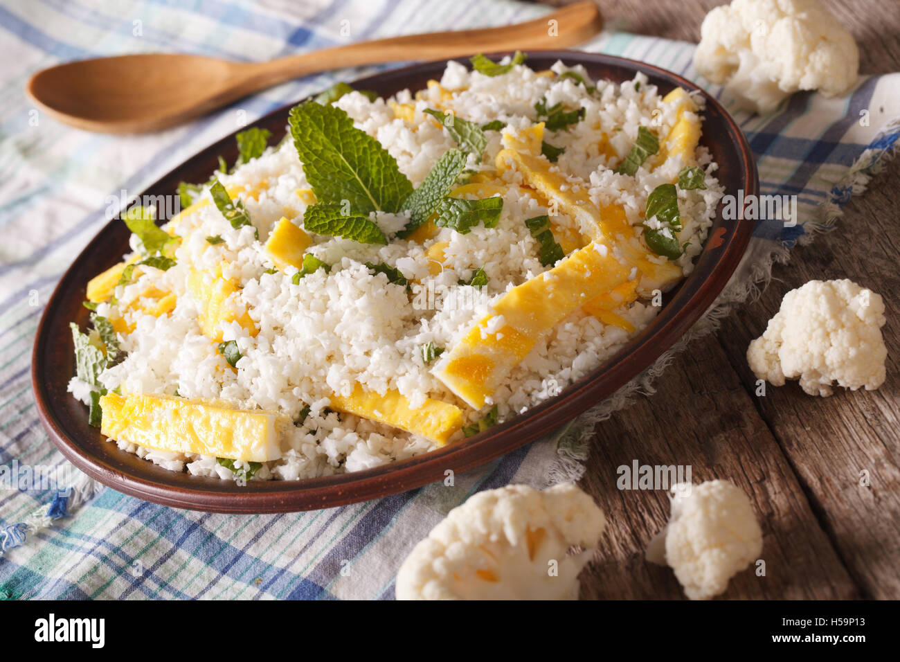 Le chou-fleur de riz avec des oeufs brouillés et de menthe pour paleo close-up sur une plaque horizontale. Banque D'Images