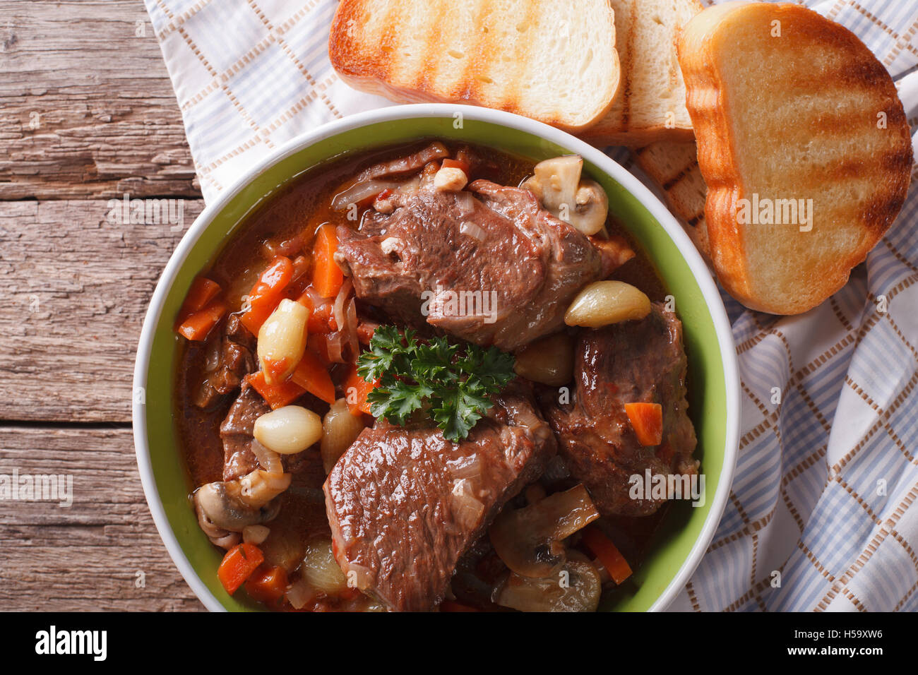 Boeuf Bourguignon rustique dans un bol sur une table close-up. Vue du dessus horizontale Banque D'Images