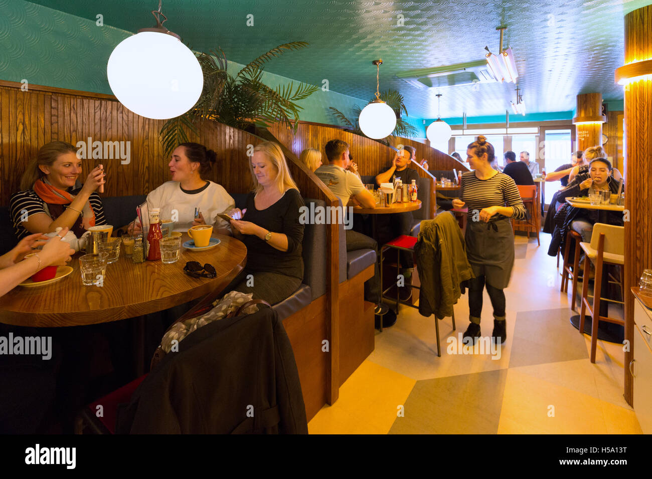 Les gens de manger dans la salle du petit-déjeuner Club Cafe, The Lanes, Brighton, East Sussex England UK Banque D'Images