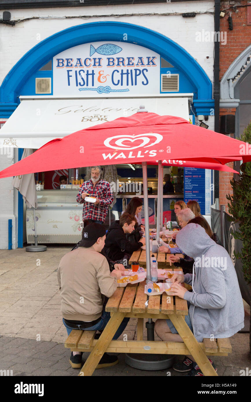 Les gens de manger du poisson et frites à l'extérieur, dans un café en bord de mer, Brighton Promenade, Brighton, East Sussex, Angleterre, Royaume-Uni Banque D'Images