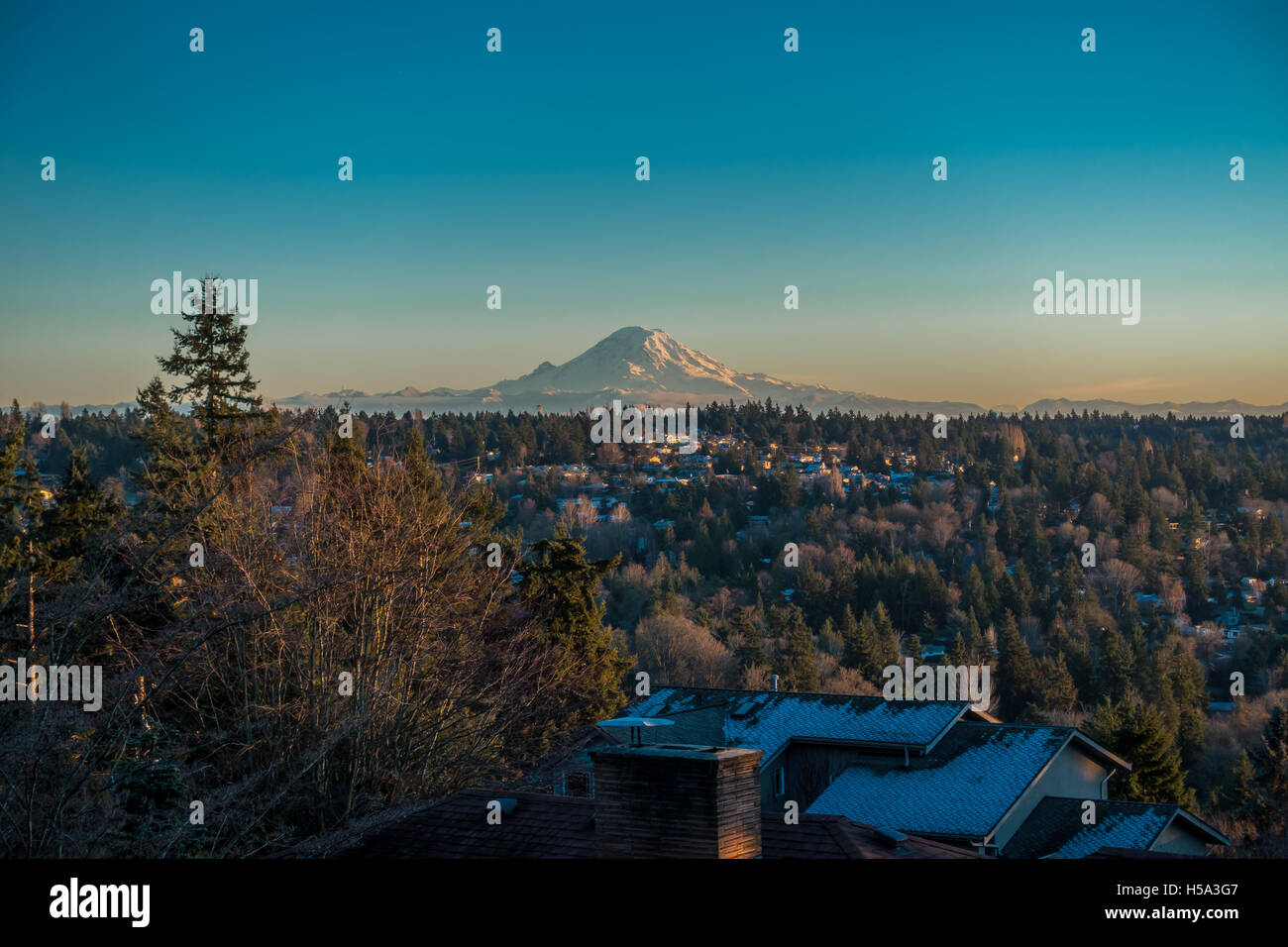 Vue du Mont Rainier sur une claire journée d'hiver avec des maisons au premier plan. Cliché pris à partir de Saint-Brieuc, Washington. Banque D'Images