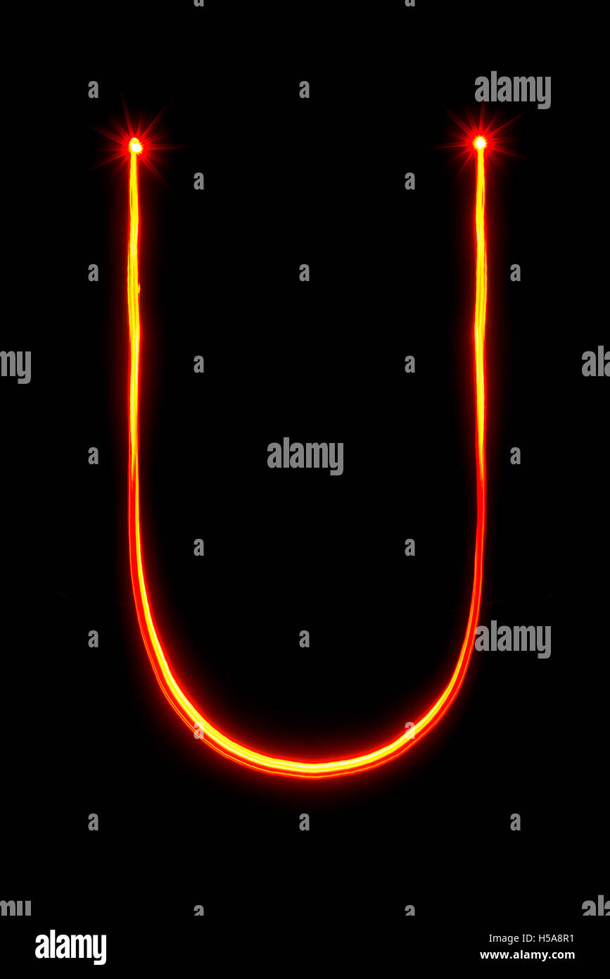 Peinture lumière rouge fine lettre U sur fond noir Banque D'Images