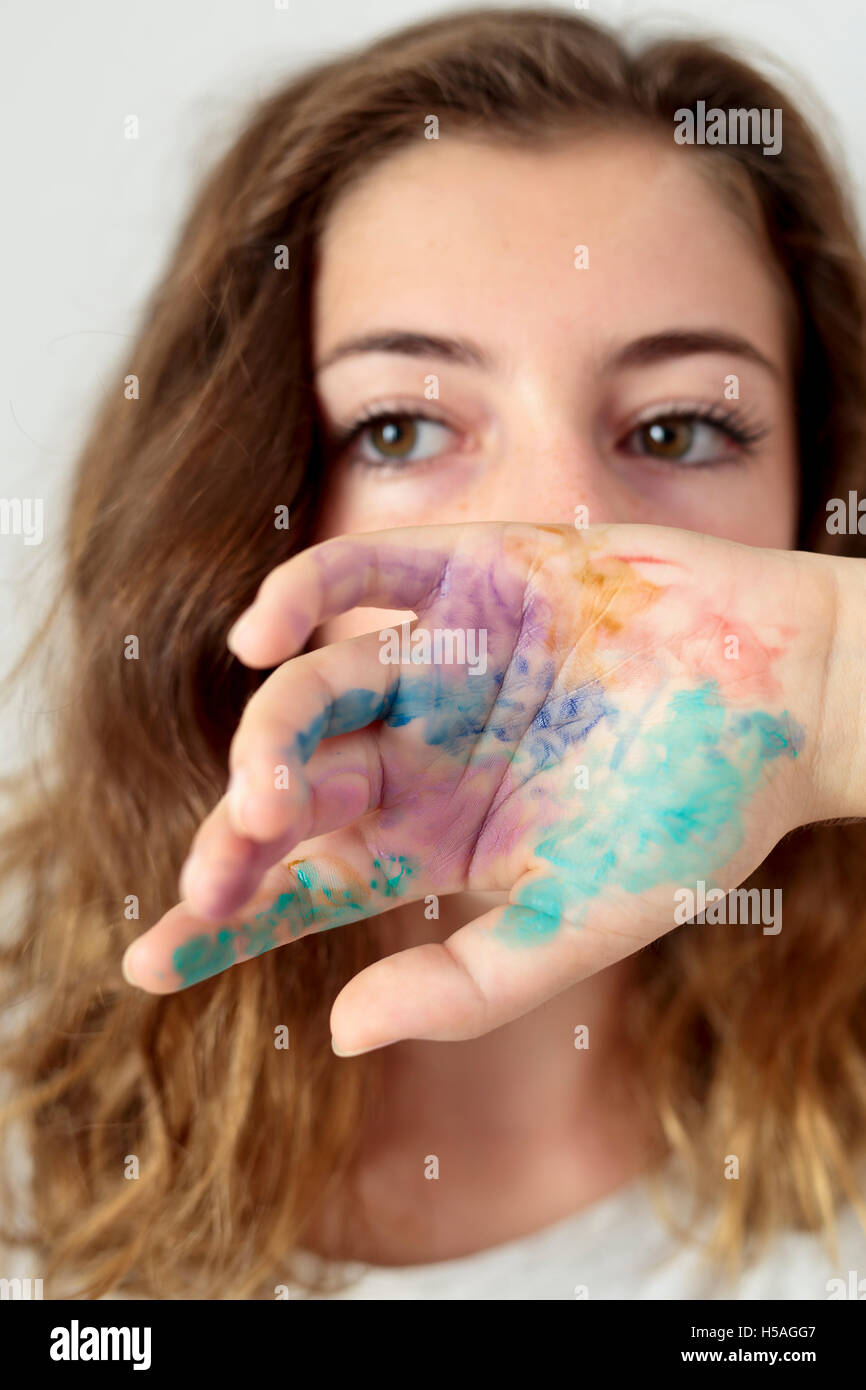 Un adolescent qui couvre une partie du visage avec un peint à la main. A la verticale. Banque D'Images