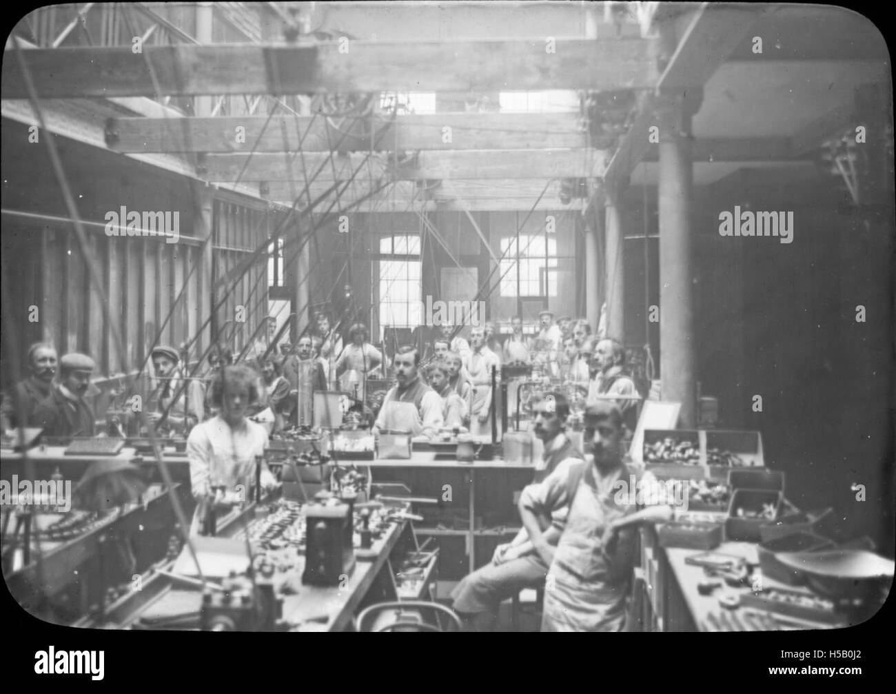 Photographie représentant des hommes et des femmes travaillant dans la fabrication de tuyaux, prise par Kapp & Peterson. L'image montre le travail et l'artisanat impliqués dans la fabrication de tuyaux au début du XXe siècle. Banque D'Images