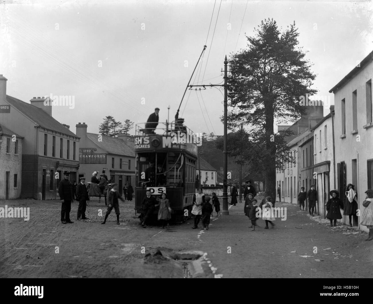 Une photographie capturant une scène de rue à Cork, en Irlande, avec un tramway et des passagers, reflétant la vie urbaine au début du XXe siècle. Banque D'Images