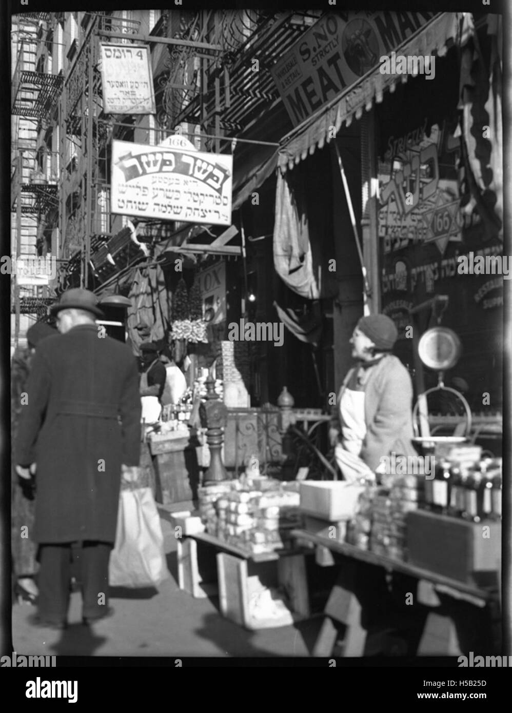 Une femme vendant différents types de gâteaux au 164 Orchard Street, New York. La photographie reflète l'atmosphère animée et vibrante du Lower East Side, un quartier connu pour sa communauté juive immigrante au début du XXe siècle. Banque D'Images