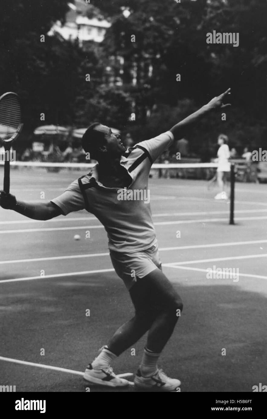 L'image montre Frank Srba, un individu notable, jouant au tennis vers 1981. L'action capture son habileté athlétique sur le terrain lors d'un match compétitif. Le tennis était un sport populaire pendant cette période, et la participation de Srba met en évidence le mode de vie actif des athlètes pendant cette période. Banque D'Images