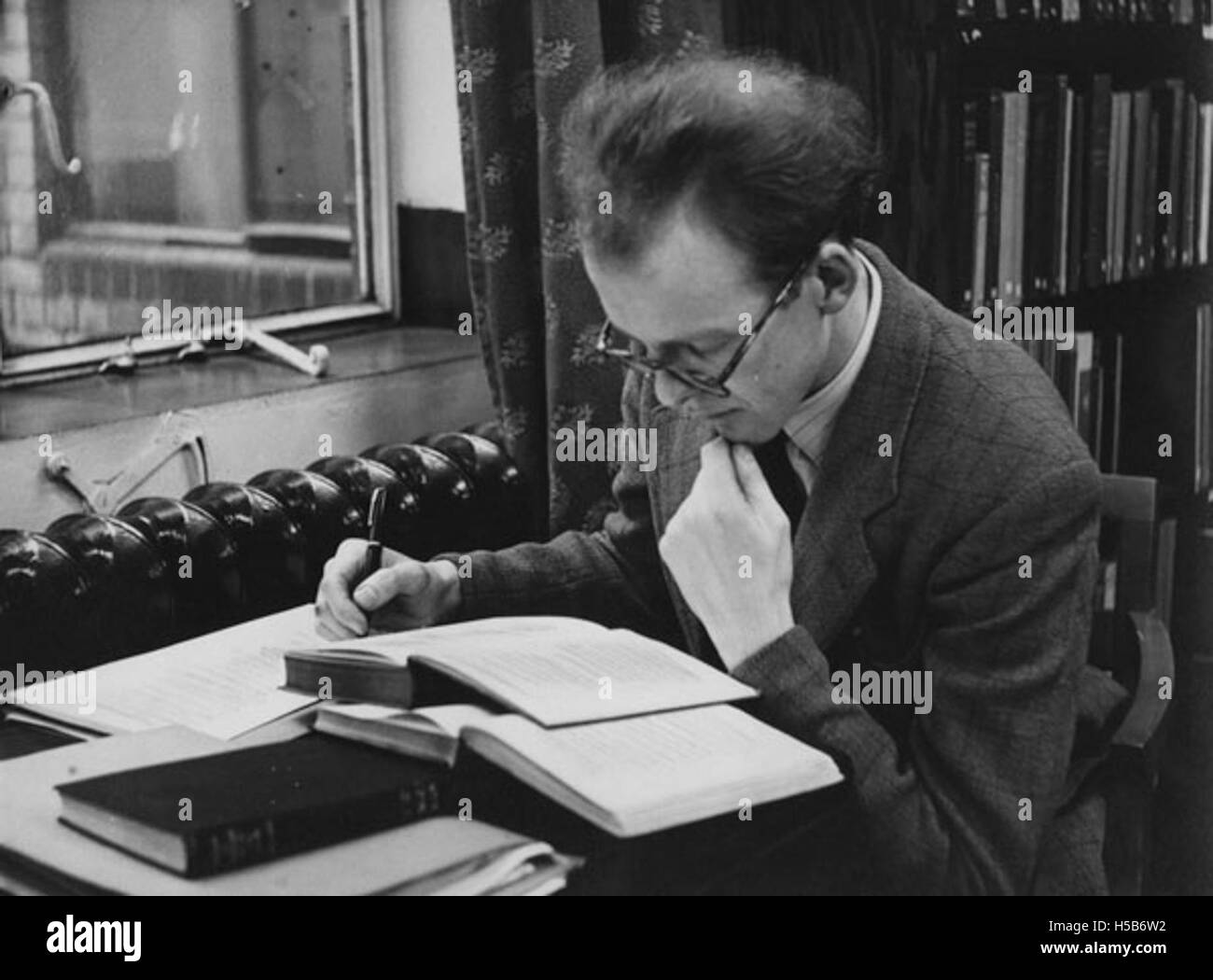 Photographie d'un étudiant étudiant étudiant dans la bibliothèque du premier étage, prise en 1951. L'image capture un moment historique dans un cadre éducatif. Banque D'Images Photographie d'un étudiant étudiant étudiant dans la bibliothèque du premier étage, prise en 1951. L'image capture un moment historique dans un cadre éducatif. Banque D'Images