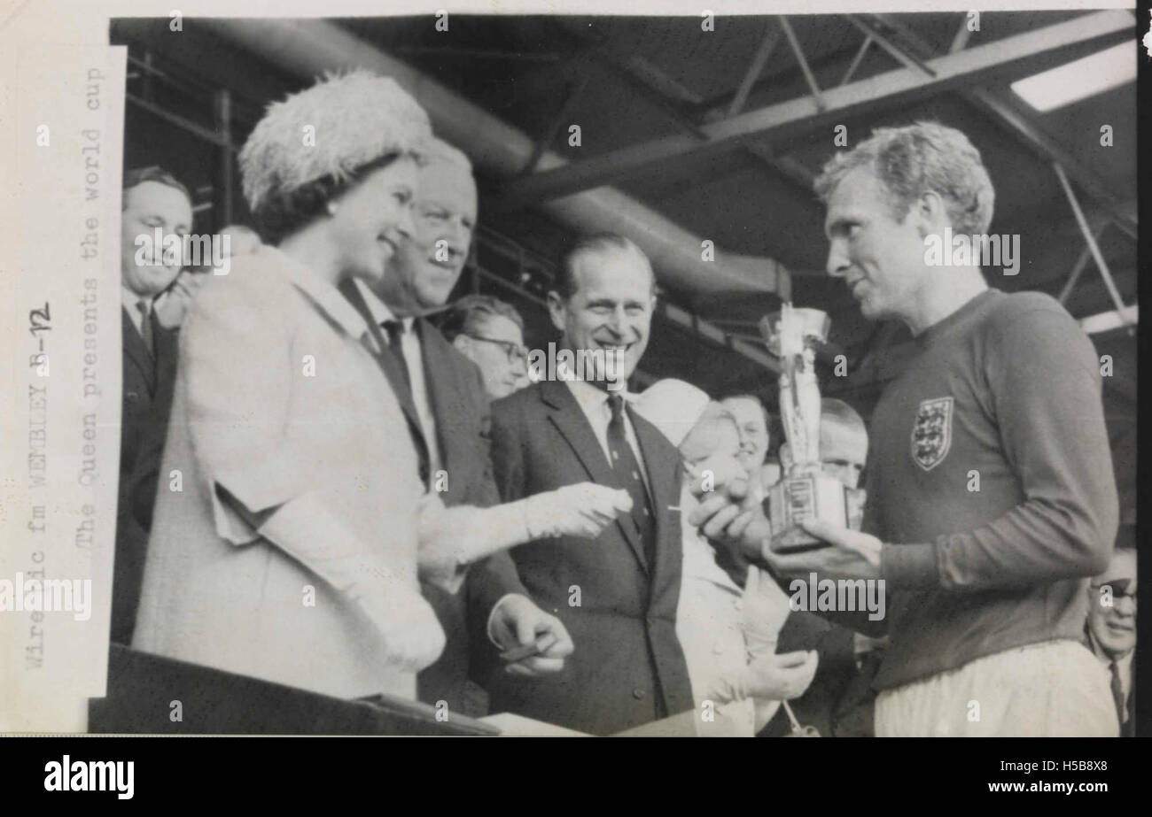 La reine Elizabeth II remet le trophée de la Coupe du monde de la FIFA 1966 au capitaine anglais Bobby Moore. Ce moment s'est produit après la victoire de l'Angleterre sur l'Allemagne de l'Ouest en finale, marquant une réussite historique dans le football anglais. Banque D'Images