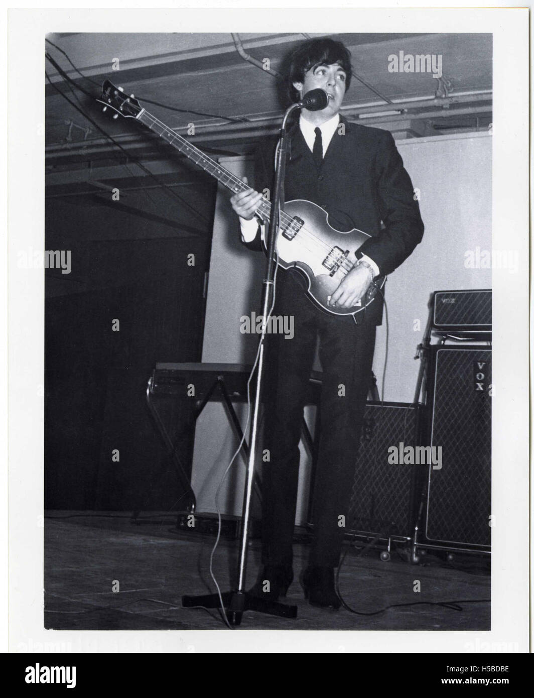 Paul McCartney joue au King's Hall de Belfast en 1964 dans le cadre de la tournée britannique des Beatles. La performance a marqué un moment emblématique de l'histoire de la musique, avec les Beatles qui ont gagné en popularité pendant cette période. Le concert est une partie importante du succès précoce du groupe et de son impact culturel. Banque D'Images