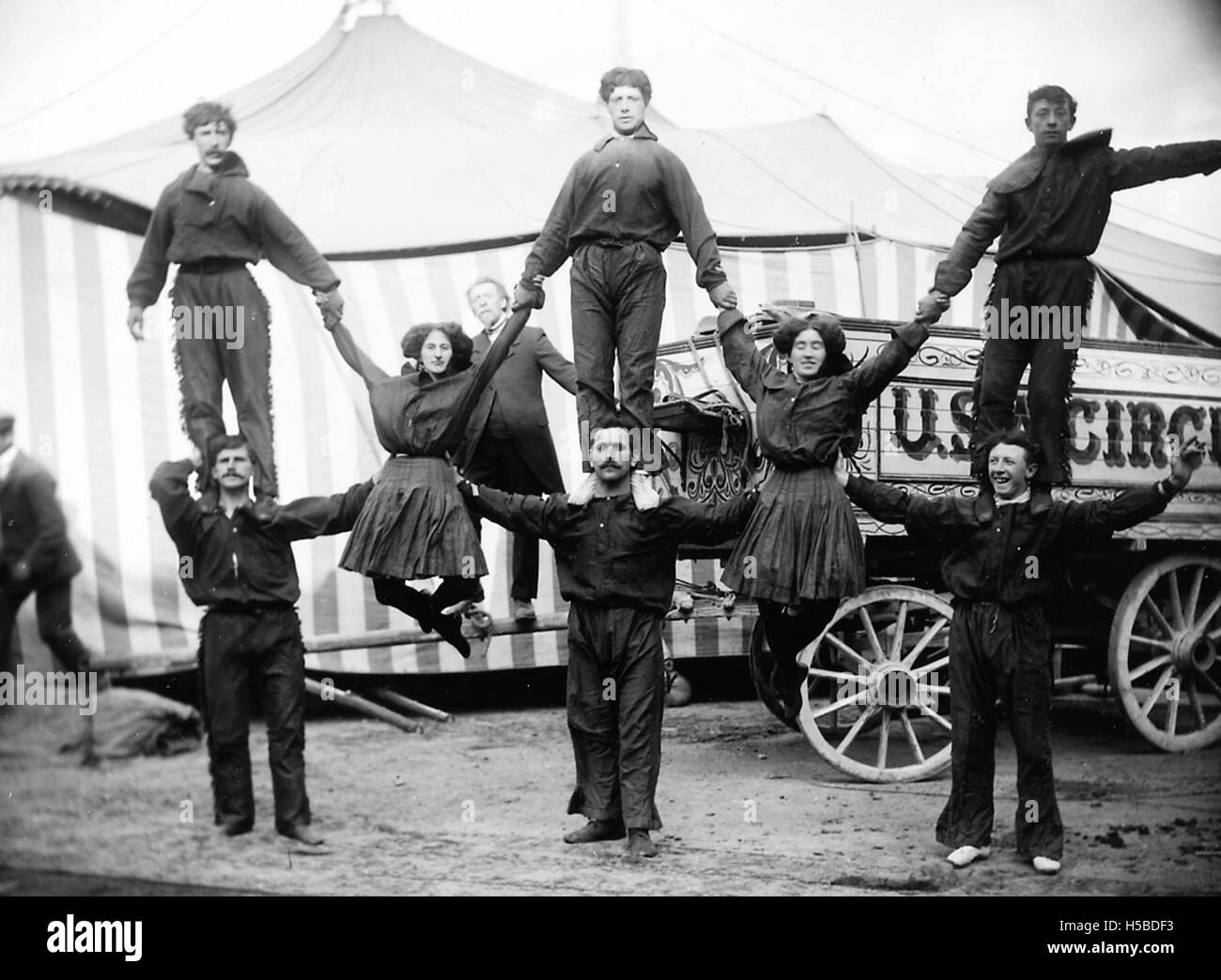 Un groupe d’artistes de cirque du Buffalo Bill’s Circus sont capturés dans une pyramide humaine, mettant en valeur leurs talents acrobatiques. L'image reflète le style de performance des numéros de cirque du début du XXe siècle, soulignant les exploits physiques et le spectacle du cirque à cette époque. Banque D'Images