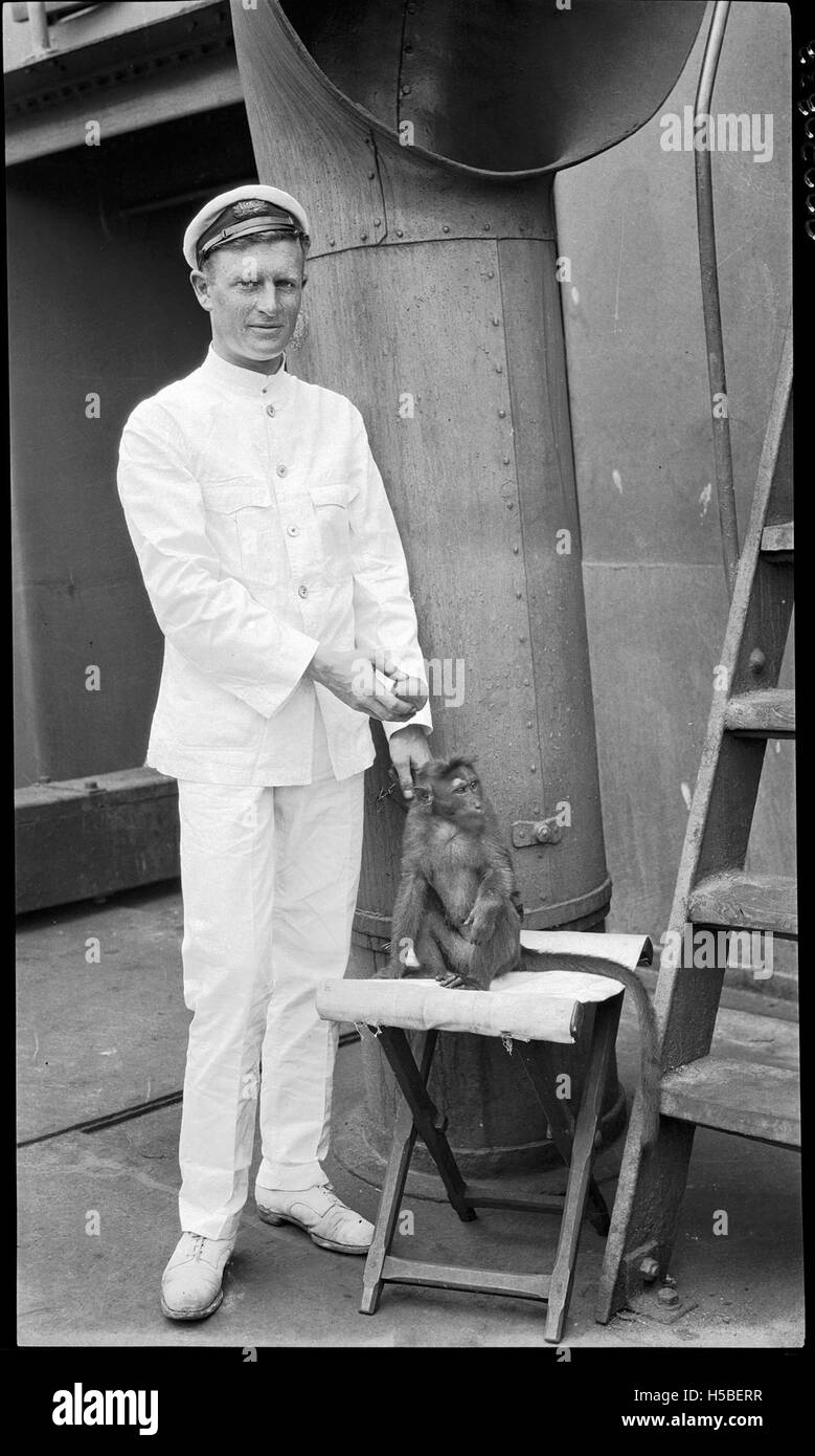 L'image montre un officier de navire anglais entre 1900 et 1930, accompagné d'un singe. Cela suggère un moment léger à bord d'un navire, peut-être pendant un voyage ou au port. Banque D'Images