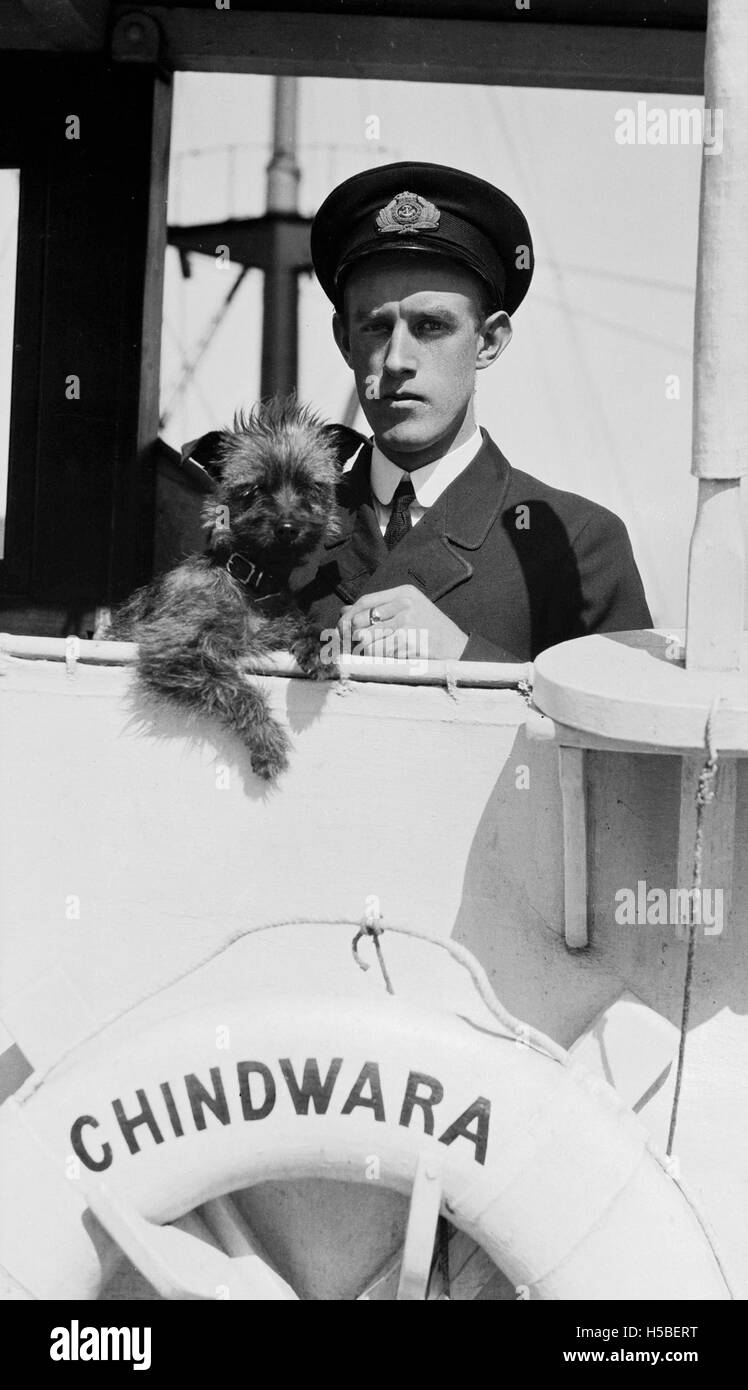 La photographie montre un officier de navire avec son chien de compagnie à bord du SS CHINDWARA, qui a opéré entre 1912 et 1933. L'image reflète la vie personnelle des membres d'équipage lors de longs voyages et la relation entre les marins et leurs animaux de compagnie. Banque D'Images