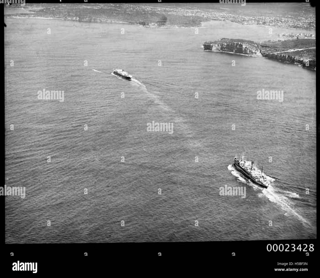 Une vue aérienne de deux bateaux à vapeur amarrés dans le port de Sydney, mettant en valeur les bateaux et la voie navigable environnante. Cette image reflète l’activité maritime au début du XXe siècle. Banque D'Images