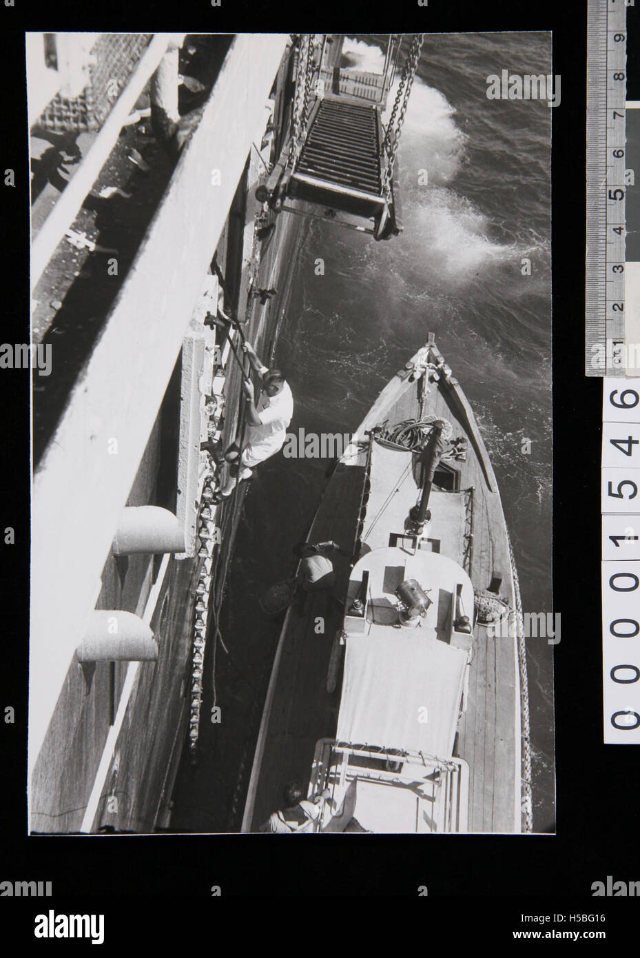 Une photographie montrant un pilote grimpant l'échelle de corde du SS New Australia, amarré à Ceylan. Cette image capture la tradition maritime du transport aérien et maritime au cours du XXe siècle. Banque D'Images Une photographie montrant un pilote grimpant l'échelle de corde du SS New Australia, amarré à Ceylan. Cette image capture la tradition maritime du transport aérien et maritime au cours du XXe siècle. Banque D'Images