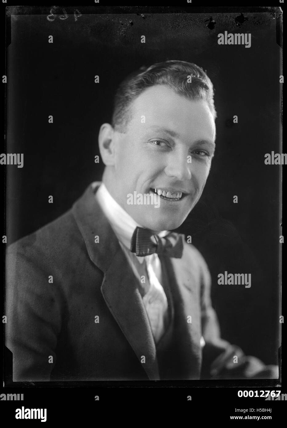 Portrait d'un jeune homme non identifié, probablement du début du XXe siècle. La photographie le capture dans une pose formelle, typique du style portrait de l'époque, avec un fond neutre et une tenue habillée. Banque D'Images