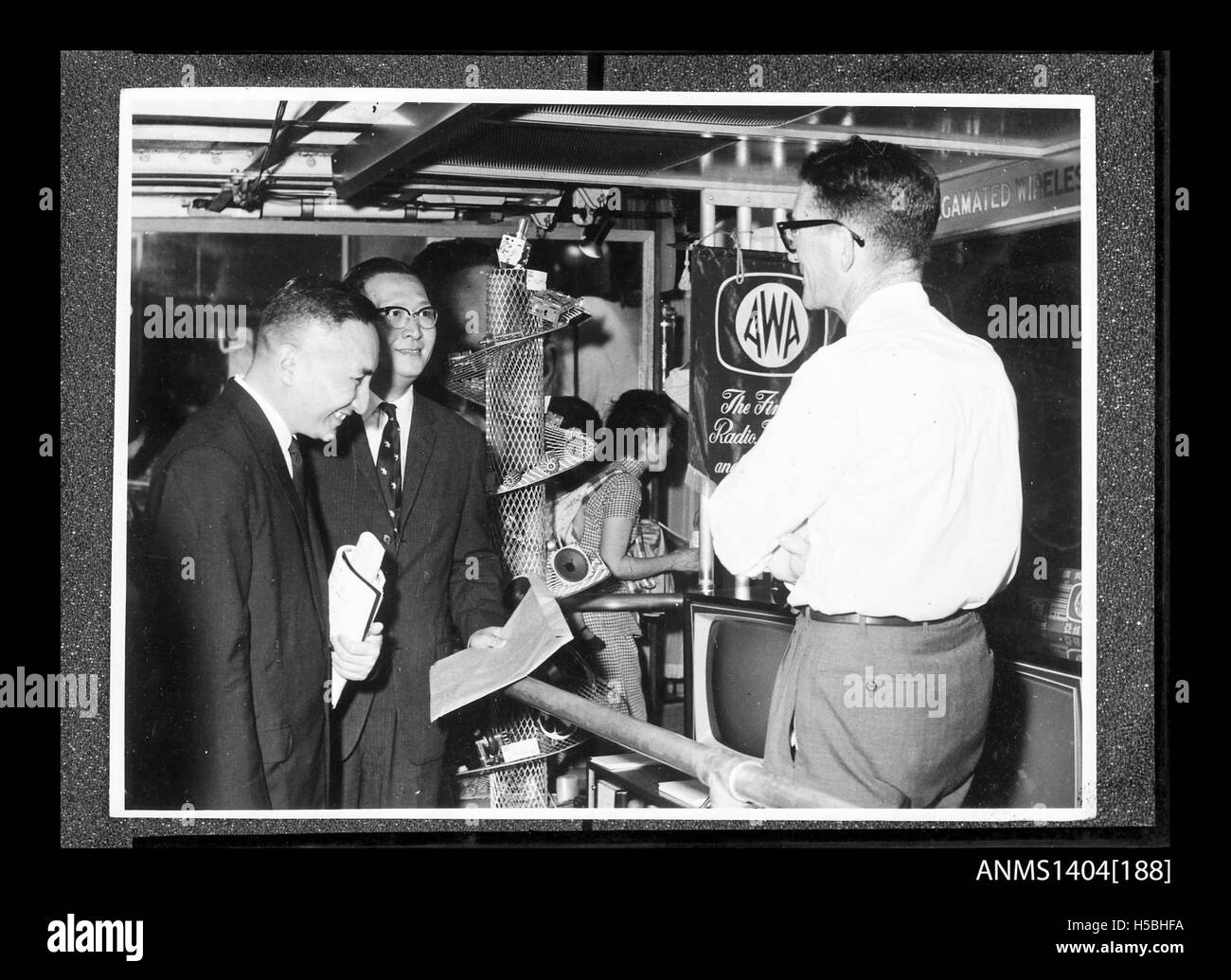 Cette image montre deux hommes examinant une exposition de la société AWA (Amalgamated Wireless Australia) à bord d'un navire de commerce, soulignant l'implication de la société dans les secteurs maritime et de la communication au début du XXe siècle. Banque D'Images