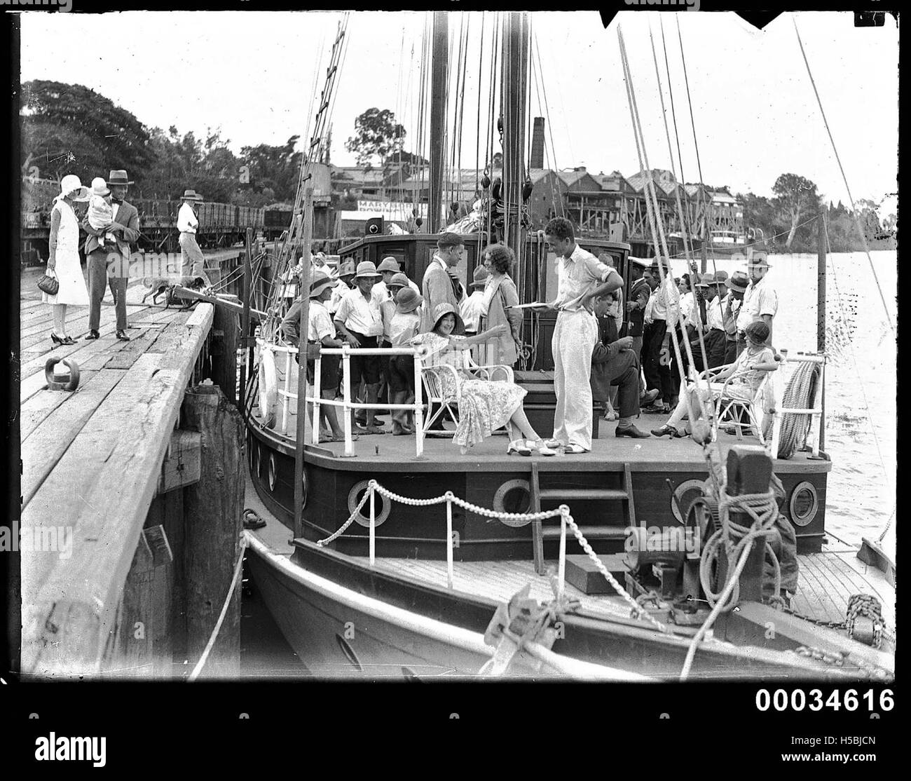 Un voilier est amarré près du Maryborough Rowing Club, où il présente le bateau et ses passagers. L'image met en évidence l'activité et la culture maritime de la région, avec le club d'aviron en arrière-plan. Banque D'Images