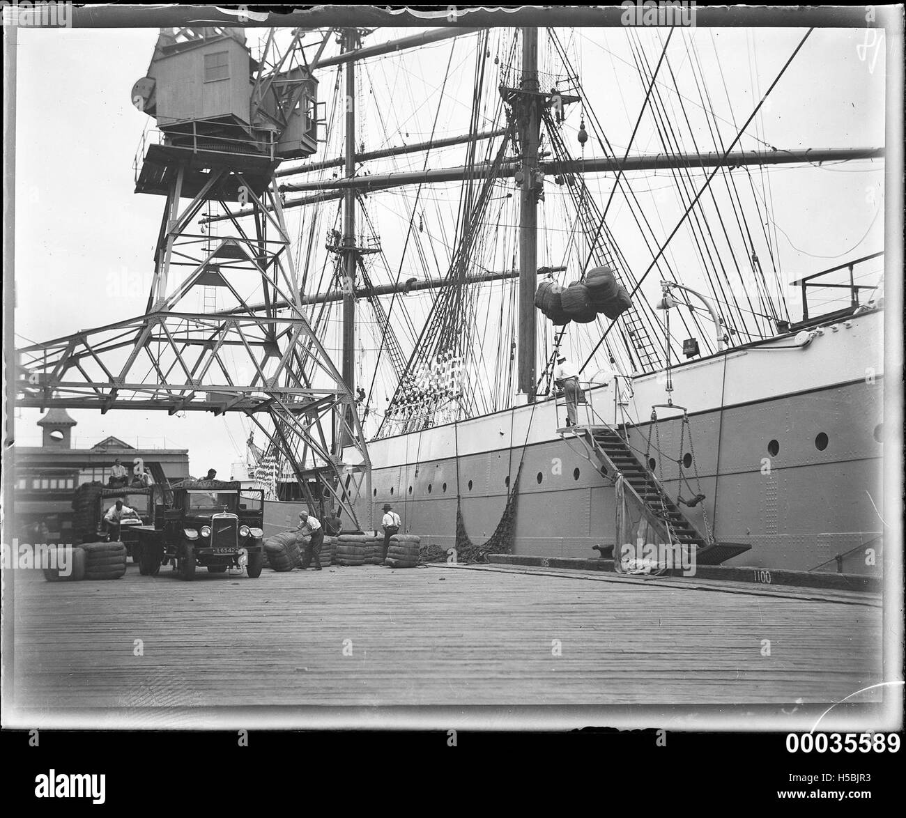 En mars 1933, des balles de laine étaient chargées dans la cale du Magdalene Vinnen, un cargo. Cette activité souligne l’importance du commerce de la laine et de la navigation maritime au début du XXe siècle. Banque D'Images