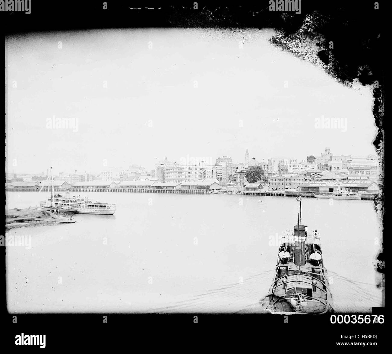 Cette photographie montre un remorqueur remorquant le SS ORUNGAL le long de la rivière Brisbane. L'image fait partie de la COLLECTION HOOD et capture le fonctionnement du transport maritime dans le fleuve au milieu du XXe siècle. Banque D'Images