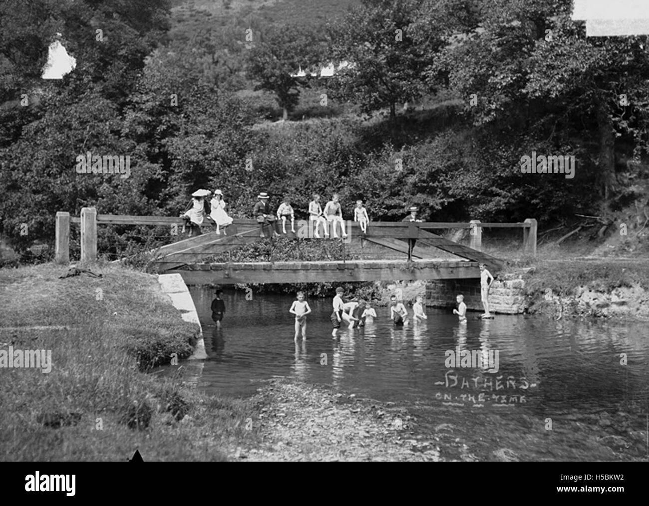 Cette photographie montre des baigneurs dans la rivière Teme. Il capture les personnes qui apprécient l'eau, reflétant les activités récréatives et l'utilisation des plans d'eau naturels pour les loisirs. Banque D'Images