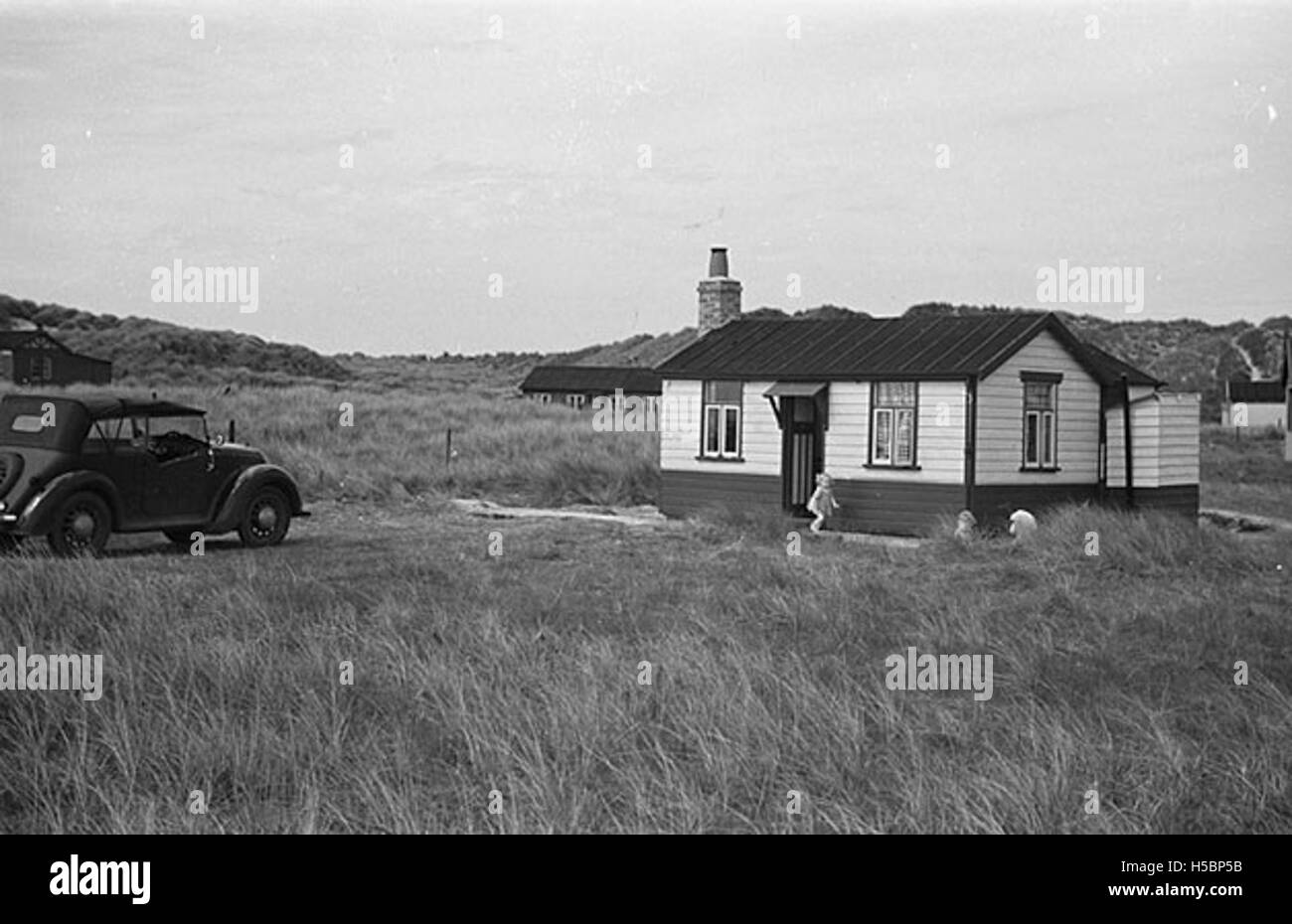Cette photographie montre la voiture de Geoff Charles garée devant le bungalow Tyn y Morfa en mai 1948. Tyn y Morfa est un endroit bien connu au pays de Galles, et l'image capture un moment dans la vie britannique d'après-guerre. Banque D'Images