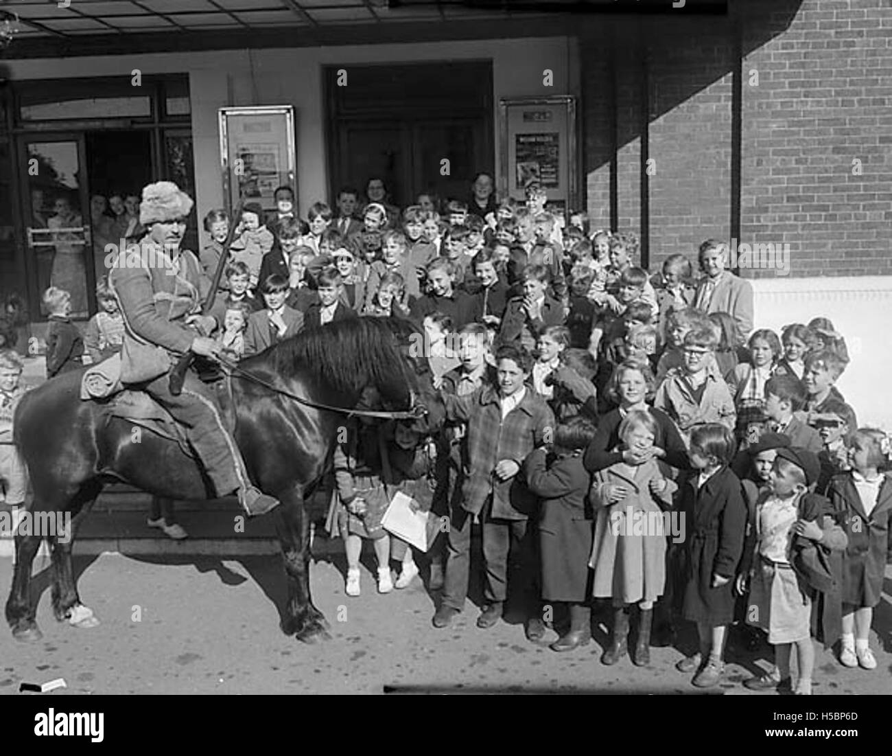 Le personnage Davy Crockett, interprété par Fess Parker, visite un cinéma à Caernarfon. Cela reflète la popularité de la série télévisée dans les années 1950, qui a captivé l'imagination du public, en particulier dans les zones rurales comme Caernarfon. Banque D'Images