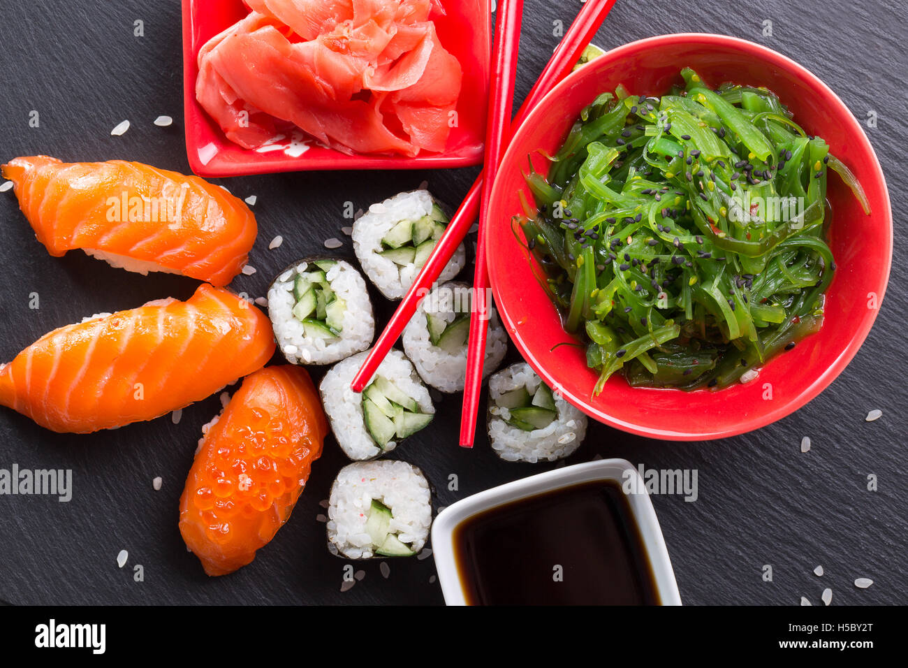 Des sushis et des rouleaux d'une salade verte sur le tableau en ardoise. Banque D'Images Des sushis et des rouleaux d'une salade verte sur le tableau en ardoise. Banque D'Images