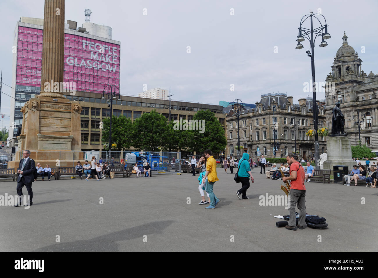 George Square et la ville chambres avec le cénotaphe situé dans le centre-ville de Glasgow center les habitants et les touristes se détendre et profiter du soleil Banque D'Images
