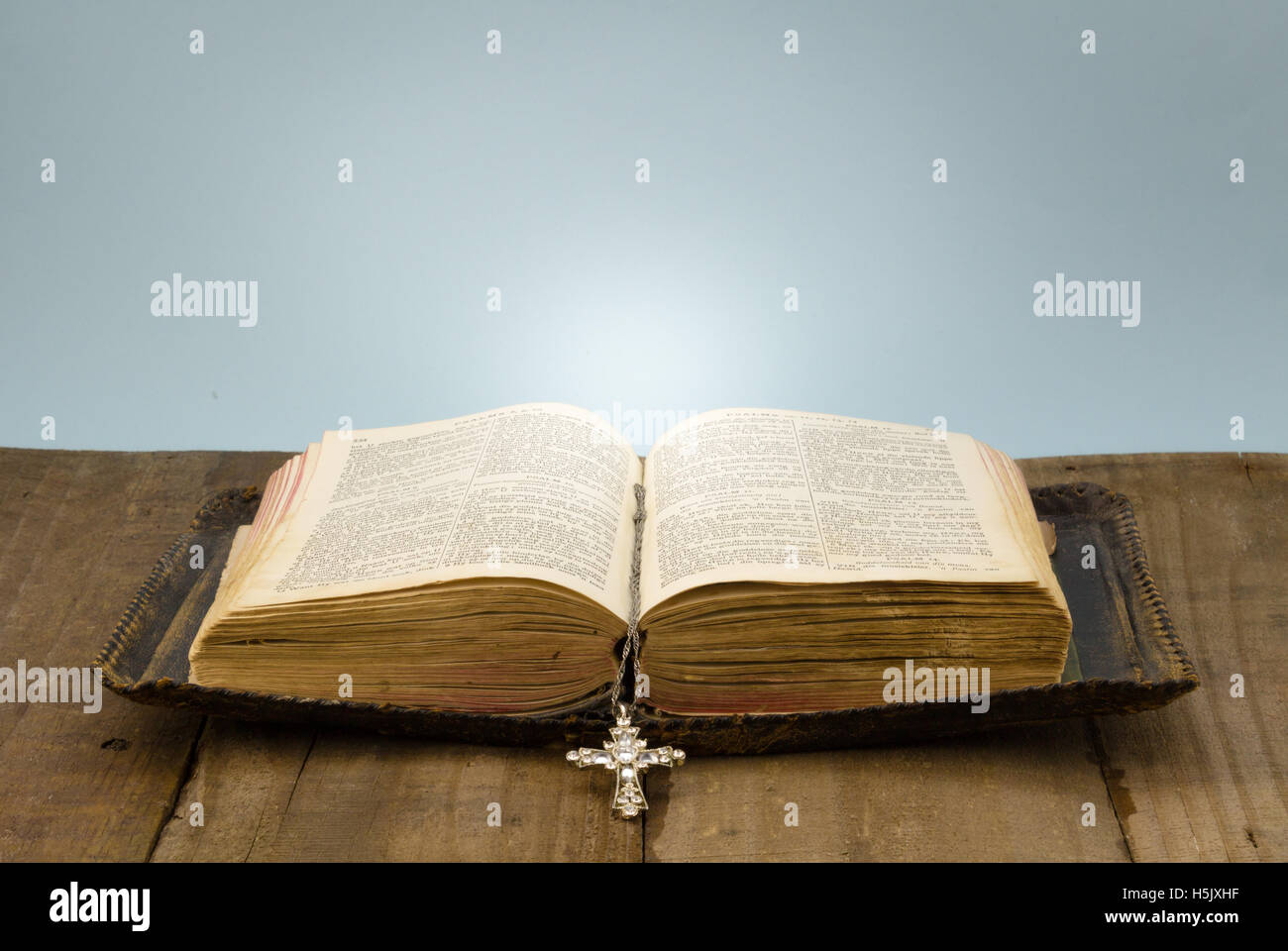 Le vieux cuir couverts Sainte Bible sur le bois brut table avec crystal cross mark Banque D'Images