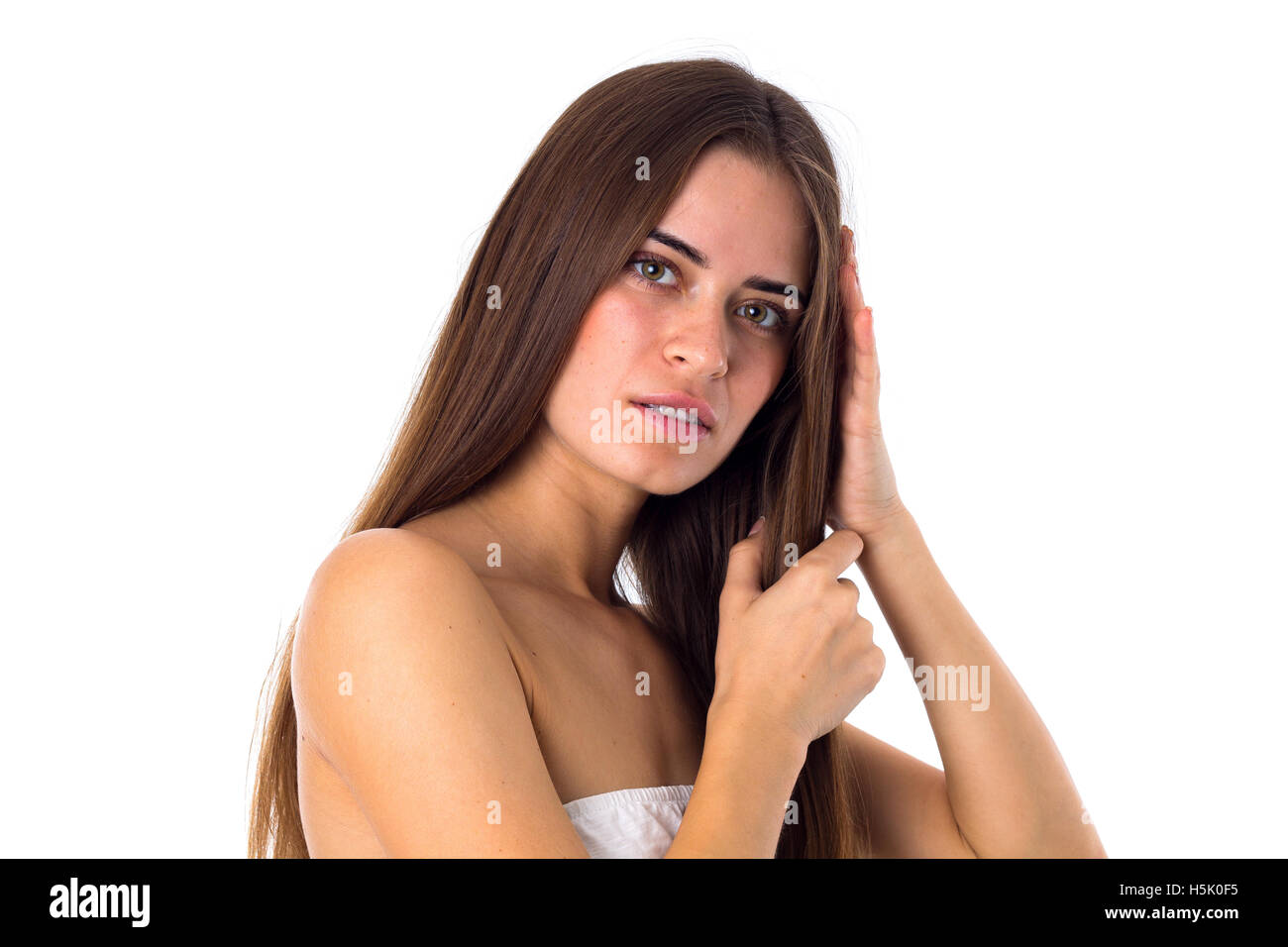 Femme debout sidewise et toucher les cheveux Banque D'Images