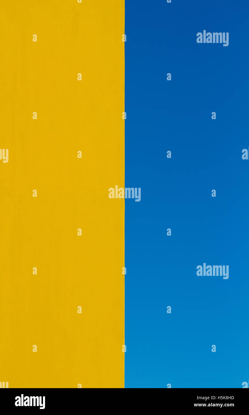 Une image abstraite de l'architecture avec un mur jaune vif la bissectrice de la trame et un ciel bleu clair sur l'autre moitié. Banque D'Images