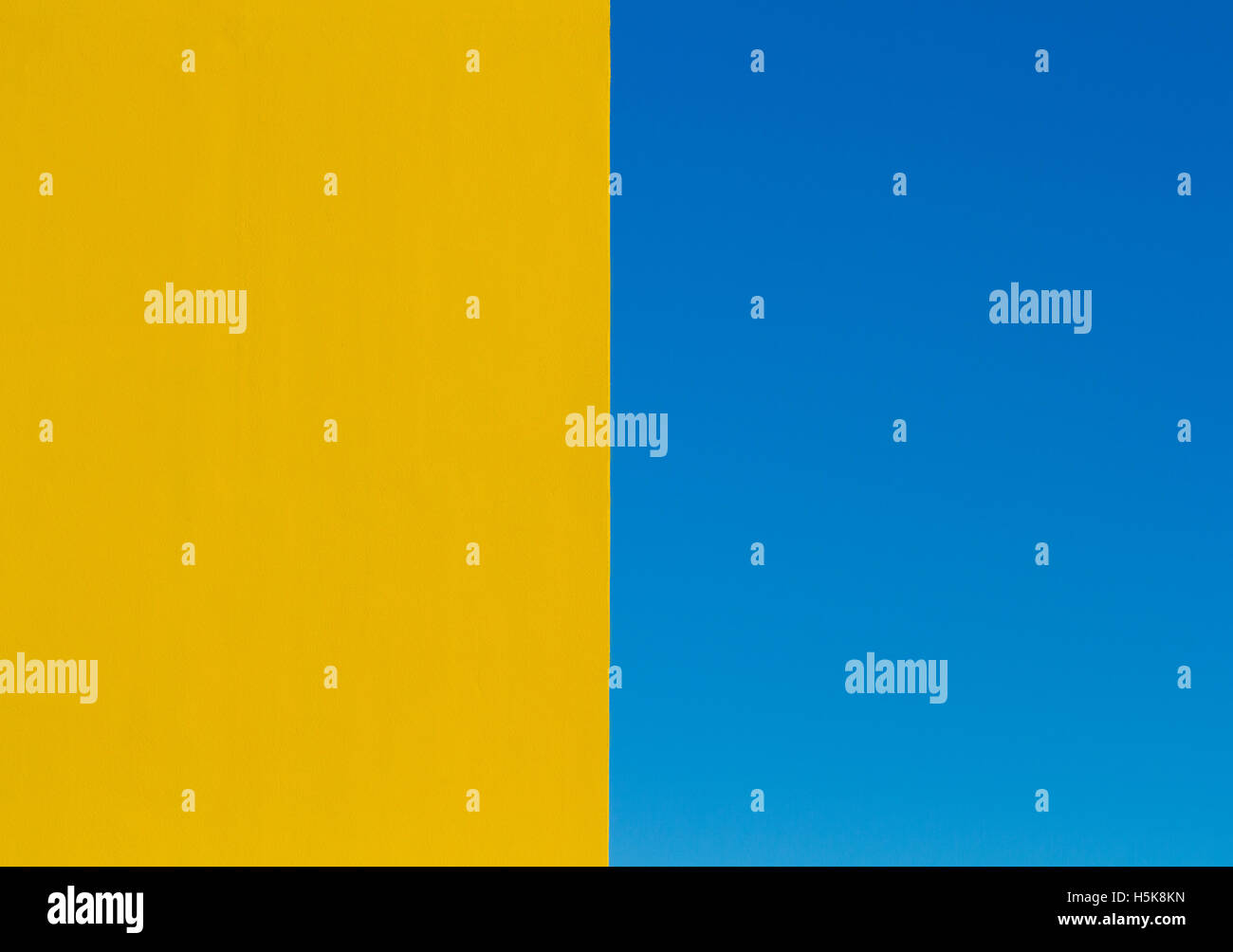 Une image abstraite de l'architecture avec un mur jaune vif la bissectrice de la trame et un ciel bleu clair sur l'autre moitié. Banque D'Images