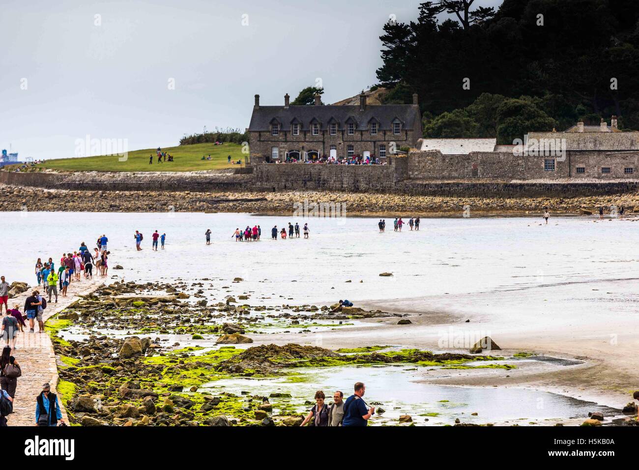 Vue de personnes être débordé sur la chaussée par la marée montante un St Michael's Bay et Sea shore à Cornwall. Banque D'Images