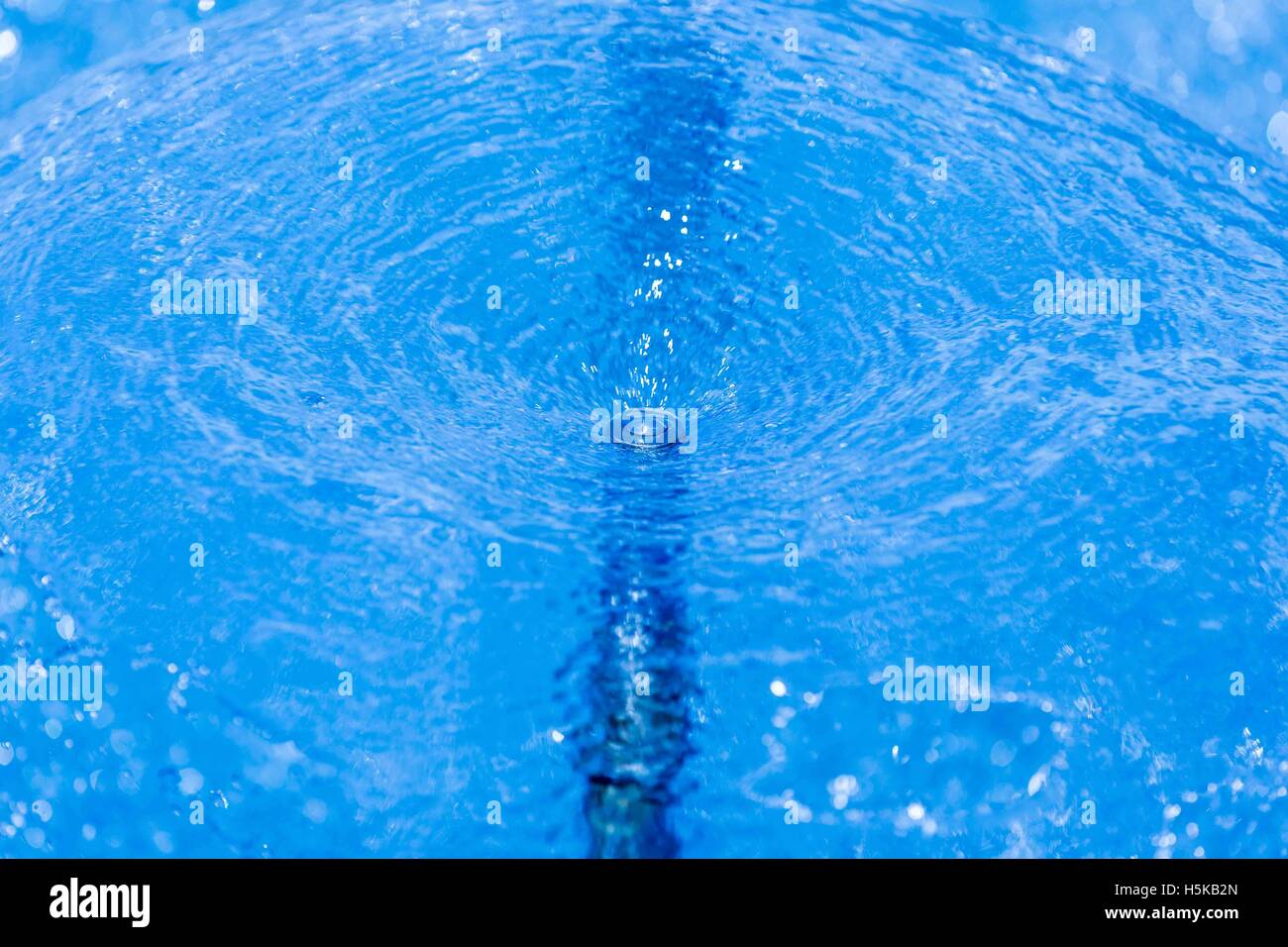 Un écran circulaire de jets d'eau en spray bleu fontaine Banque D'Images