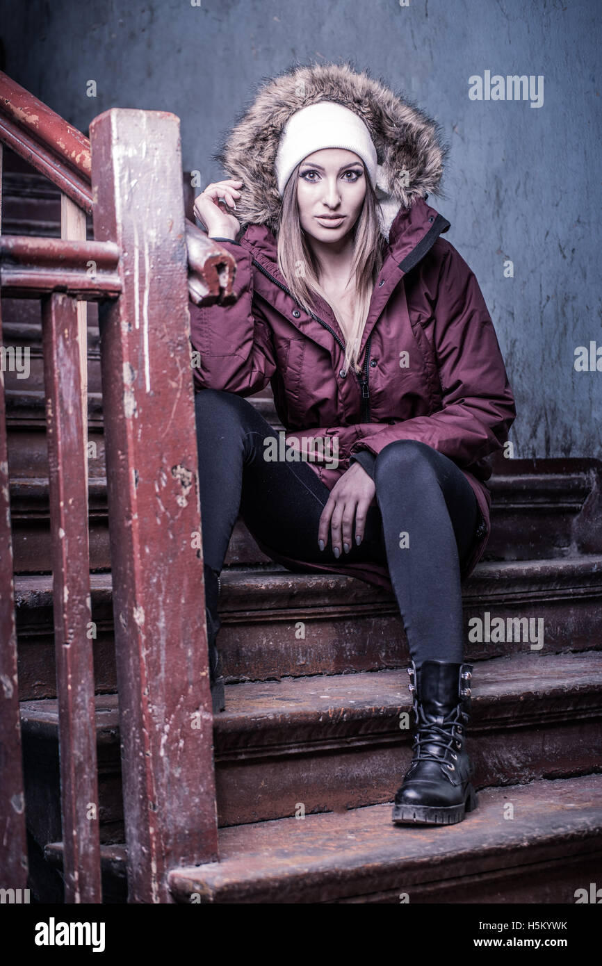 Cute woman in winter coat on staircase Banque D'Images