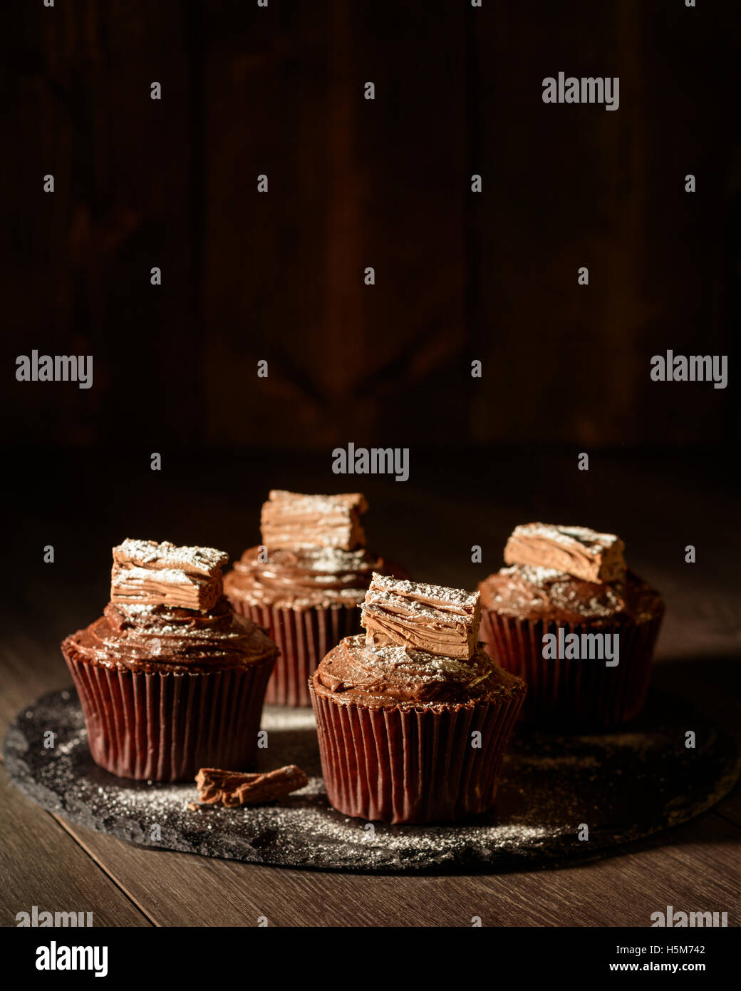 Gâteaux au chocolat riche sur ardoise bord saupoudrés de sucre glace Banque D'Images