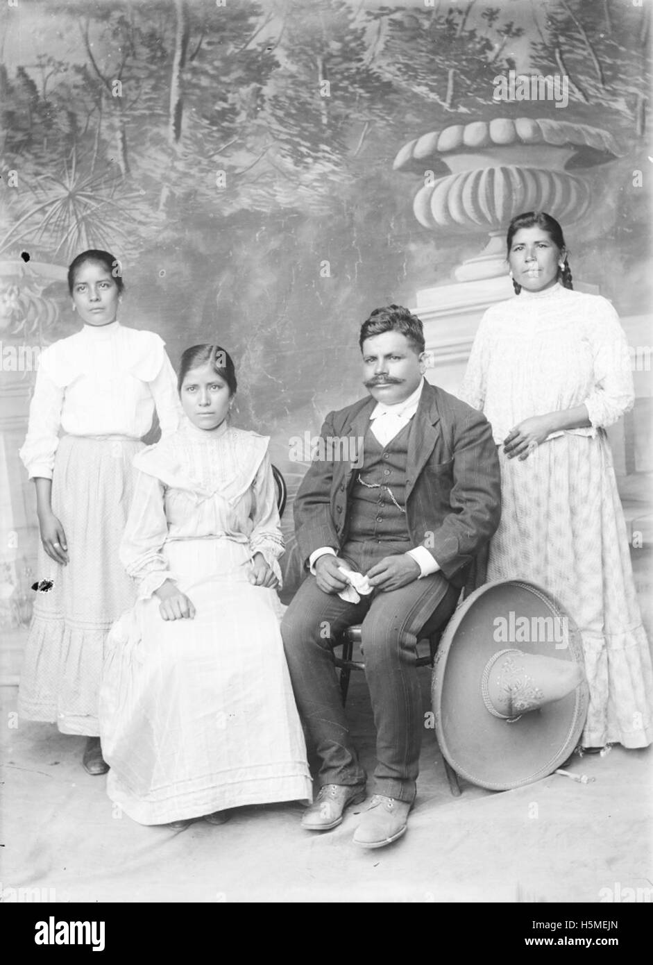 Ce portrait représente trois femmes et un homme, probablement pris au début du XXe siècle. Il saisit la mode, la dynamique sociale et les rôles des individus dans un contexte historique spécifique. Banque D'Images