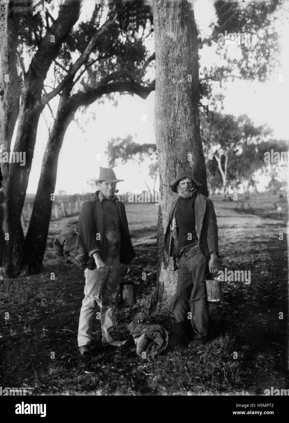 Une photographie d'environ 1905 montrant des swagmen, des travailleurs itinérants, debout sous les arbres dans le Queensland rural, capturant la vie de l'époque. Banque D'Images
