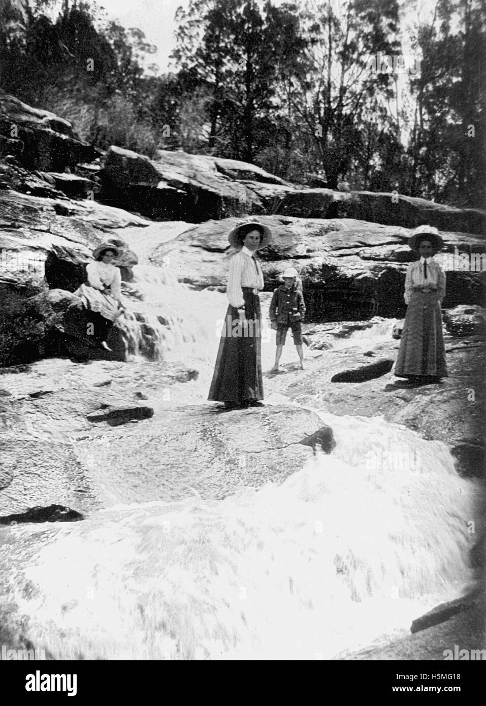 Cette image montre des dames élégamment habillées et un petit enfant observant les chutes de Winstead, une caractéristique naturelle de l'eau. La scène capture la sérénité des chutes et l'interaction paisible des visiteurs avec la nature. Banque D'Images Cette image montre des dames élégamment habillées et un petit enfant observant les chutes de Winstead, une caractéristique naturelle de l'eau. La scène capture la sérénité des chutes et l'interaction paisible des visiteurs avec la nature. Banque D'Images