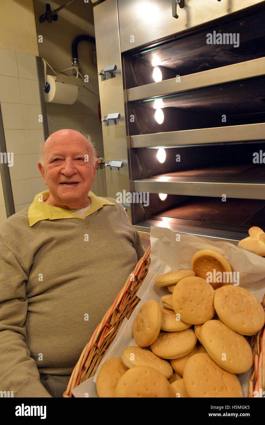 Smiling baker holding miche de pain Banque D'Images
