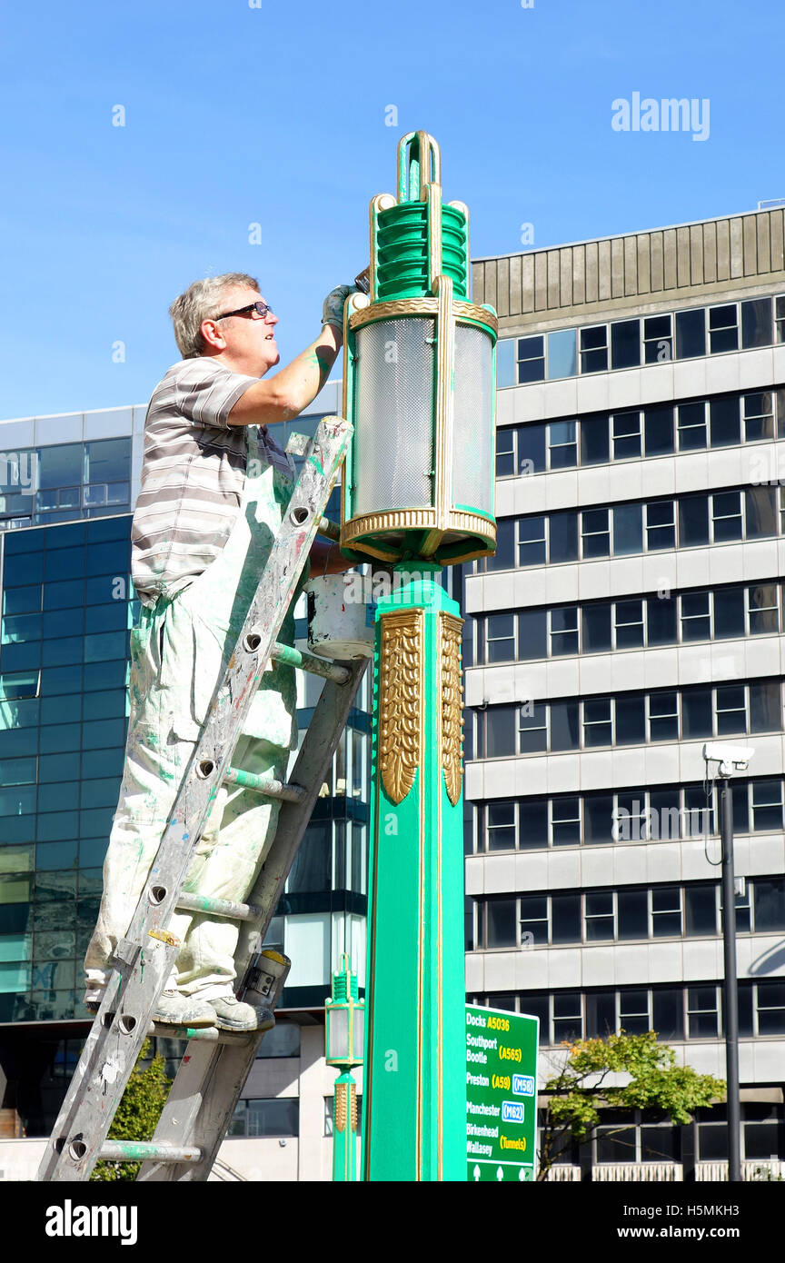 Une peinture ouvrier qualifié l'éclairage de rue à Liverpool, Angleterre, Royaume-Uni Banque D'Images