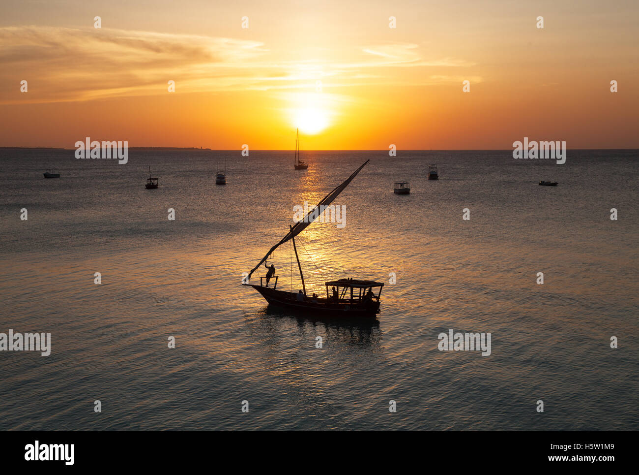Un soleil jaune foncé avec un bateau au premier plan . Banque D'Images