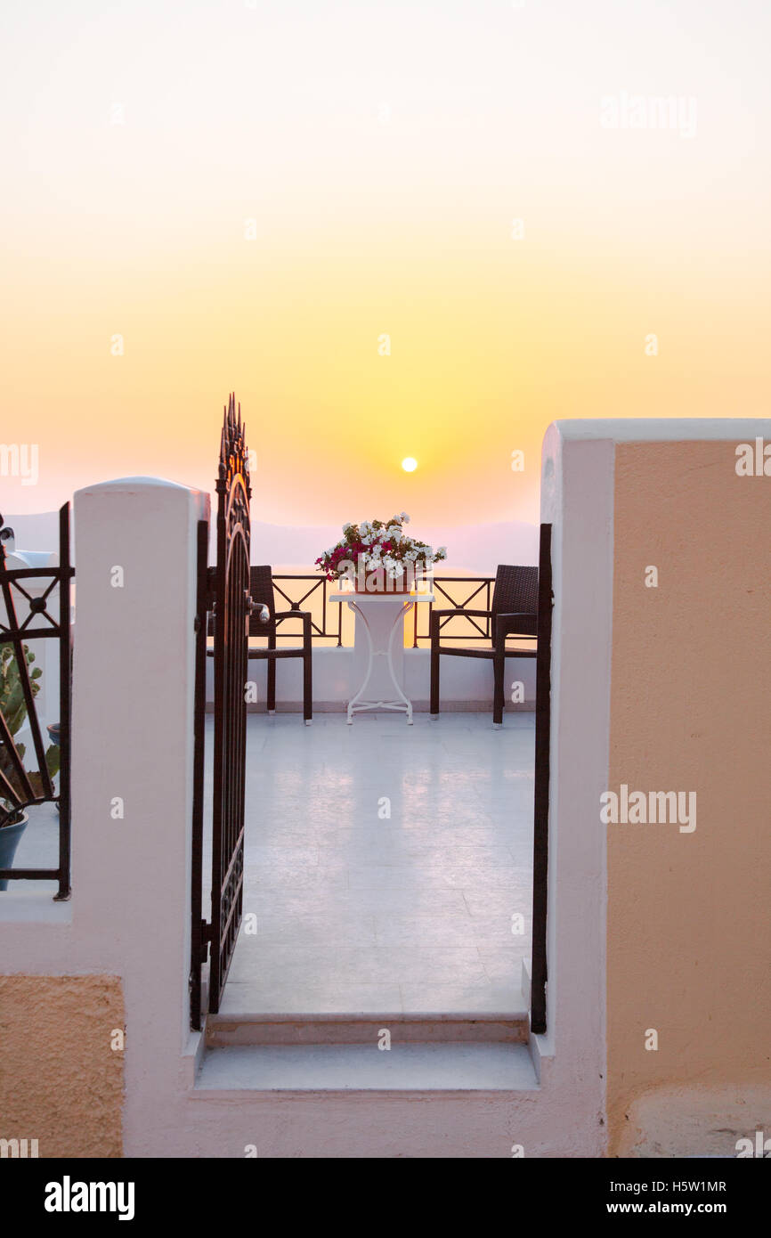 Une vue sur une porte menant à un patio et ci-dessous, c'est la mer et un magnifique coucher de soleil Banque D'Images